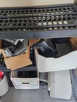 Assorted rack-mount audio units in open boxes on shelving