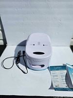 Closed sanitizer with power cord and manuals visible