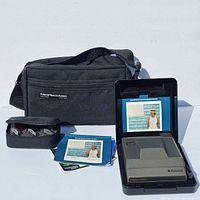 Full kit showing camera, clamshell case, manuals, filter pouch and shoulder bag