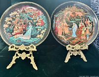 Both plates on stands showing painted fronts and gold rims