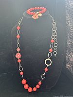 Bracelet and necklace displayed on black bust, overall view