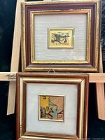 Both framed miniature artworks displayed on easel