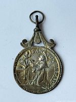 Obverse of silver devotional medal showing robed figure, rope edge, and bail
