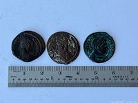 Three coins next to metric ruler