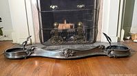 Full view of pewter toned fireplace surround in front of hearth