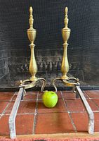 Front view showing both brass uprights, scrolling legs, and iron log supports