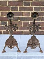 front view of both andirons showing decorative motifs and patina