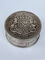 Top view showing embossed Dutch coat of arms design and circular form