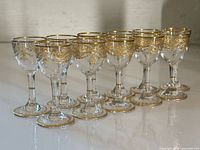 Full set of 11 gilt etched liqueur glasses grouped