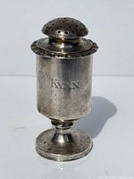 Full view of silver spice shaker showing shape and lid