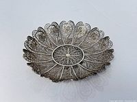 Top view of silver filigree dish showing full floral pattern and scalloped rim