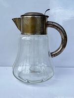 Overall view of glass pitcher with silver-plated top, handle and internal ice tube