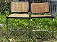 Front view of both Cesca chairs showing cane seats and backs, chrome bases
