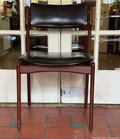Front view of Erik Buch teak chair showing black leather seat and backrest