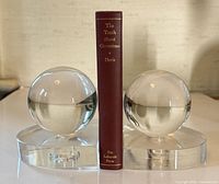 Both glass sphere bookends side by side with book for scale