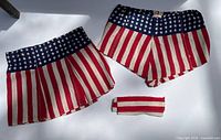 Top view of American flag patterned skirt, shorts and fabric band on flat surface