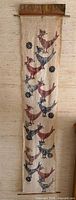 Full view of batik wall hanging showing design, wood slats and copper plaque