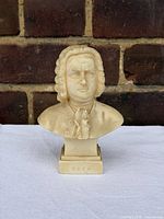Front view of cream resin bust of Johann Sebastian Bach on plinth labeled "BACH"
