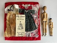 Lot overview showing both dolls, multiple clothing pieces, brochure