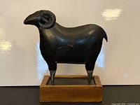 full view of tin ram sculpture on wood base