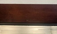 Close view of wooden frame and mirror surface showing finish and minor wear