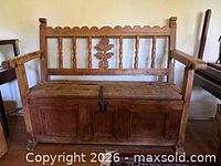 Front view of pine settle bench showing carved back, arms, seat, latch