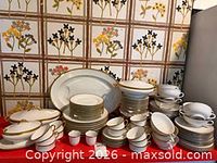 Full grouping of white and gold Limoges and Pickard china pieces on table