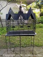 Full view of cage on stand outdoors