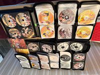 Multiple binders opened showing rows of Chinese DVDs