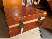 Full view of trunk closed, showing wood grain and front hardware