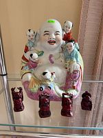 Front view of ceramic Buddha and four resin Buddhas
