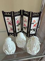 Screen and three figurines grouped