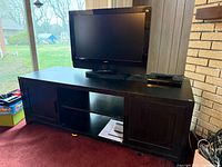 Cabinet with Vizio TV on top, doors and shelves visible