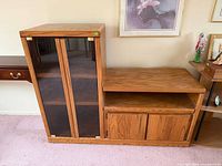 Front view of entire oak entertainment center showing glass media cabinet and lower cabinet