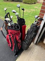 Four golf bags standing with clubs visible