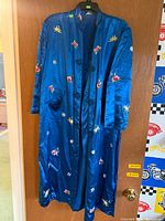 Front view of blue silk robe hanging on door