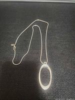 Full necklace laid flat showing chain, pendant, clasp