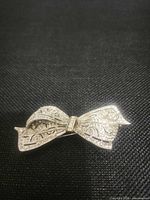 Front view of silver-tone bow brooch showing marcasite and rhinestones