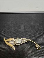 Front view showing leaf design, cabochon, rhinestone