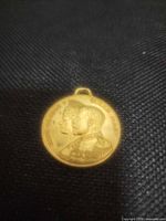 Obverse of medal with conjoined busts and suspension loop