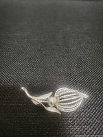 Front view of silver-tone floral brooch