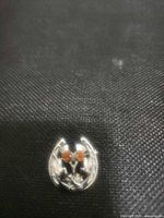 Front view of silver-tone brooch showing orange stones