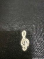 Front view showing treble clef shape and rhinestones