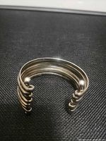 Front view showing five parallel bands and coiled ends with ball finials