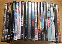 Front spines of eighteen DVD cases showing titles and wear
