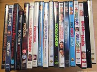 Row of 18 DVD movie cases, spines facing camera to show titles and general wear