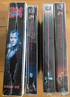 Spines of four shrink-wrapped 24 DVD box sets seasons 1-4