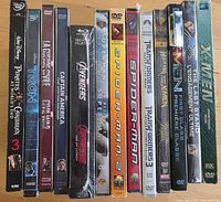 Front view of thirteen sealed action DVD cases standing upright