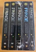 Front view of five sealed Fringe DVD season sets wrapped together