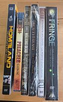 Spine view of six sealed DVD season sets showing titles and season numbers